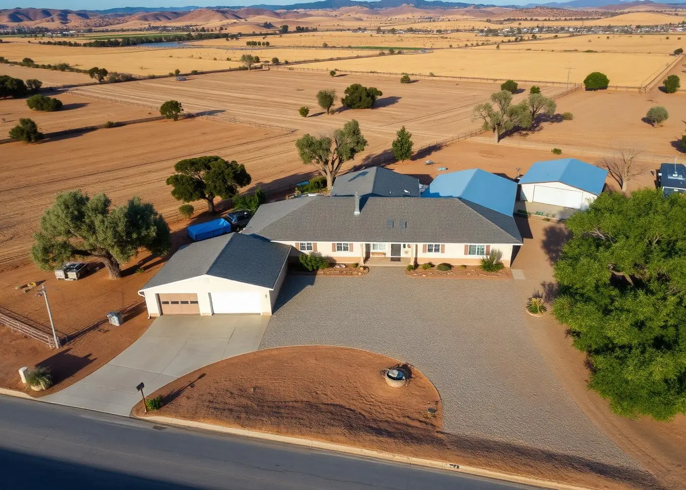Aerial view of a single-story ranch home on a half-acre lot with a detached shop, gravel driveway, and surrounding farmland